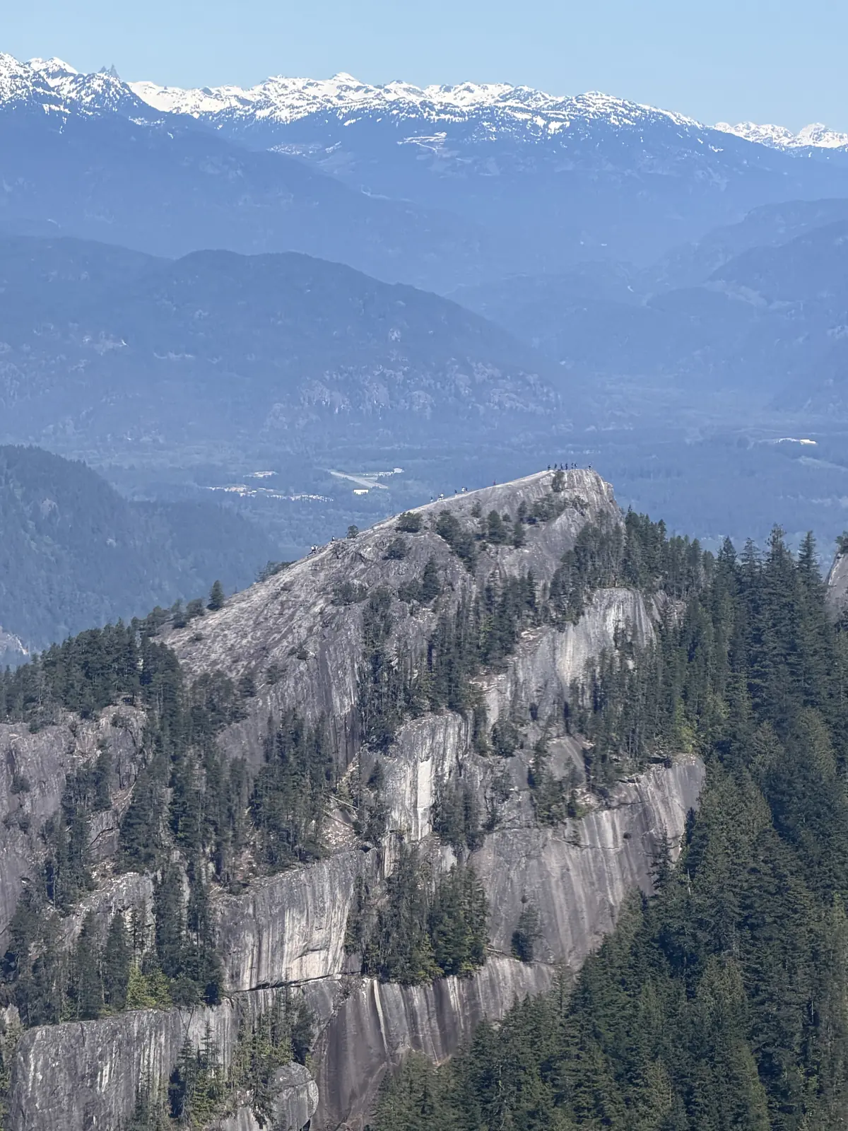 Stawamus Chief cliff with hikers at the top, in Squamish, British Columbia