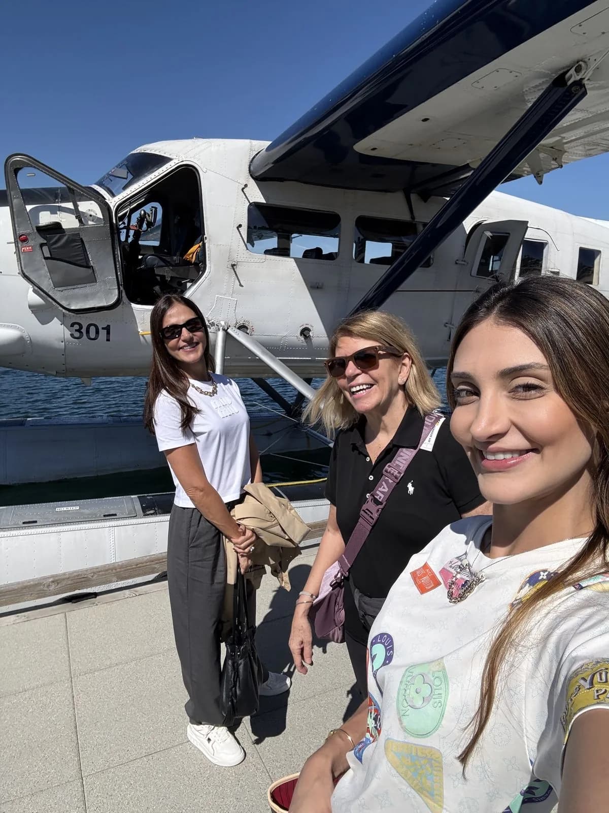 Clientes sonriendo junto al hidroavión de Harbour Air en Victoria